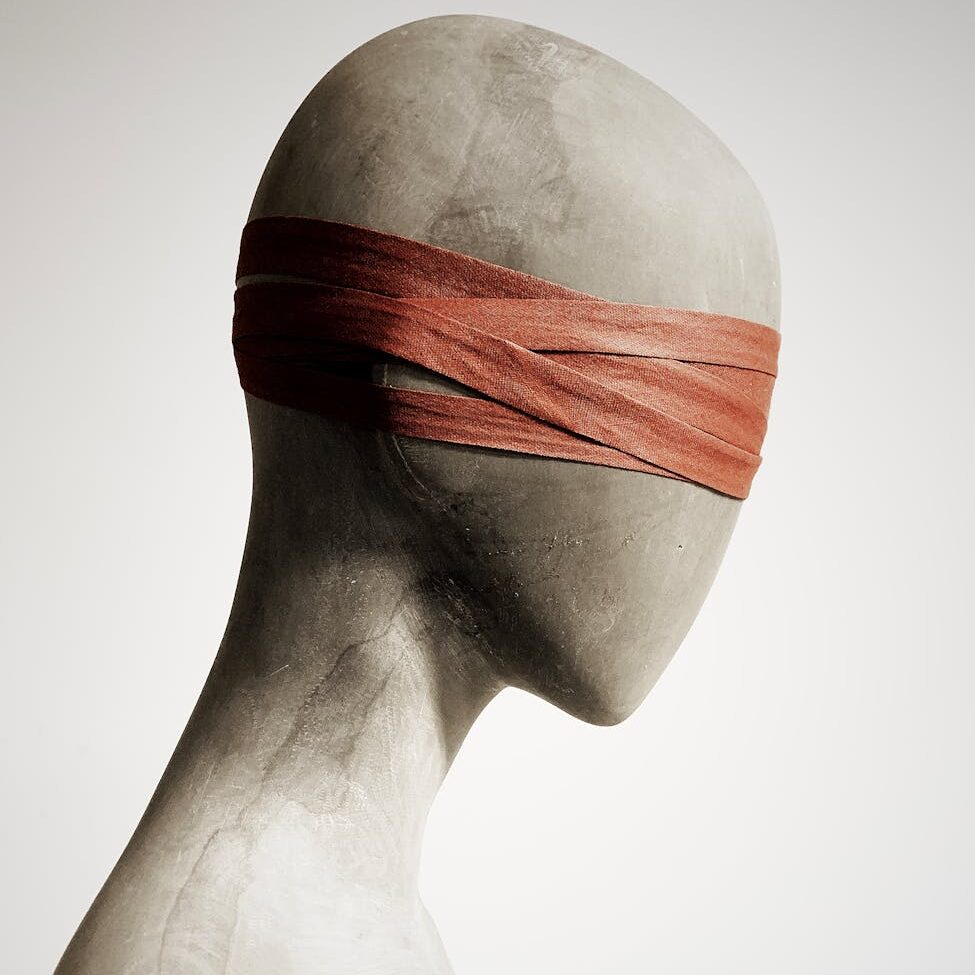 mannequin head wrapped with leather strips