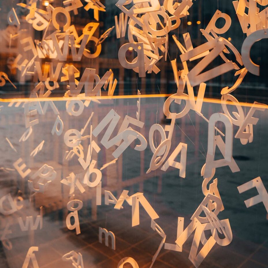 wooden alphabets hanging near glass window